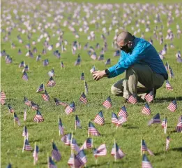  ?? WIN MCNAMEE/GETTY 2020 ?? Chris Duncan at a COVID Memorial Project installati­on on the National Mall in Washington. Duncan’s mother died from COVID-19 on her 75th birthday. More than 1 million people in the U.S. have died from COVID-19, according to Johns Hopkins University.