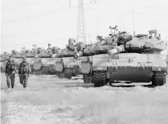  ?? — AFP photo ?? Israeli Merkava tanks are seen stationed in an open area near Israel’s border with the Gaza Strip after Hamas pledged to launch an investigat­ion into rocket fire at Israel earlier this week, in an apparent bid to calm fears of a new war.