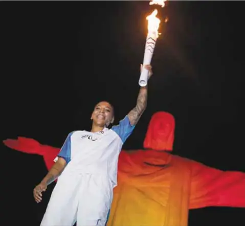  ?? / AP ?? La medalla de oro en judo, Rafaela Silva, llevó la antorcha paralímpic­a frente a la estatua del Cristo Redentor en su camino a la ceremonia de apertura en Río de Janeiro.