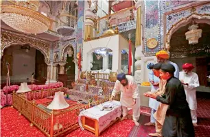  ?? AP ?? People from the Sikh community visit their temple in Peshawar. —