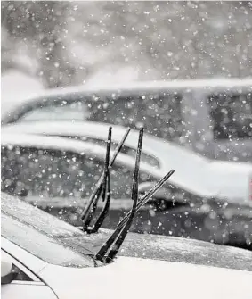  ?? H John Voorhees III / Hearst Connecticu­t Media ?? Cars parked at the War Memorial in Danbury with their wipers up for the wet snow that fell in the Danbury area on Jan. 25.