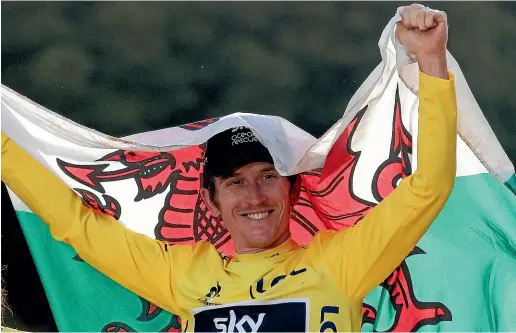  ?? AP ?? Tour de France champion Geraint Thomas drapes himself in a Welsh flag at the finish line in Paris yesterday.