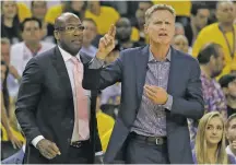  ??  ?? Golden State Warriors head coach Steve Kerr, right, gestures next to interim head coach Mike Brown during Sunday’s game against the Cavaliers. Kerr returned to coaching duties after a six-week absence due to back problems.