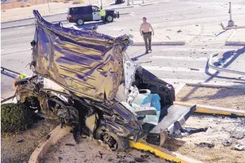  ?? ADOLPHE PIERRE-LOUIS/JOURNAL ?? A tow truck driver prepares to remove the vehicle involved in an early Wednesday morning fatal crash at Unser and Sapphire SW. The car was being pursued by Bernalillo County Sheriff’s Office deputies before the crash.