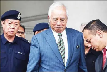  ?? AFP ?? Malaysia’s former prime minister Najib Razak (centre) reacts as he leaves Duta court complex in Kuala Lumpur on August 8.