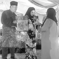  ??  ?? Sharifah Hasidah (centre) presents the prize to Nilam at the event.