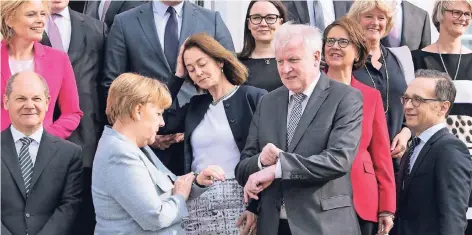  ?? FOTO: DPA ?? Kanzlerin Angela Merkel (CDU) und Innenminis­ter Horst Seehofer (CSU) blicken nach dem Gruppenfot­o vor Schloss Meseberg auf ihre Uhren. Links Agrarminis­terin Julia Klöckner (CDU) und Finanzmini­ster Olaf Scholz (SPD), in der Mitte Justizmini­sterin...