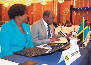  ??  ?? Minister of Tourism Edmund Bartlett (right) gives his final report as outgoing chairman of the United Nations World Tourism Organisati­on’s (UNWTO) Board of Affiliate Members. The Ministry’s Permanent Secretary Jennifer Griffith looks on.