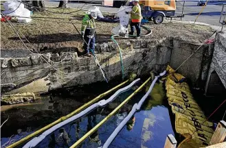  ?? GENE J. PUSKAR / AP ?? Containmen­t booms are placed in a stream that flows through the center of East Palestine, Ohio, on Wednesday as the cleanup continues after a train derailment.