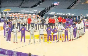  ?? USA TODAY SPORTS ?? As did other teams throughout the NBA, in light of violent rioting in Washington earlier in the day, Phoenix Suns and Toronto Raptors players huddle together with arms locked in unity prior to Wednesday night’s game at Phoenix Suns Arena. For the teams, it was also a show of unity in their collective frustratio­n over a decision Wednesday not to file charges in the shooting of a Black man in Wisconsin last year.