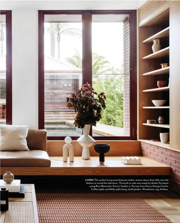  ??  ?? LIVING The sunken living area features timber-veneer doors that slide over the shelves to reveal the television. The built-in sofa was made by Atelier Furniture using Rino Mastrotto ‘Antico’ leather in Terrone from Decor Design Centre. Coffee table and Nelly table lamp, both Jardan. Woodnotes rug, Anibou.