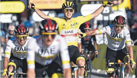  ?? FOTO: ANNE-CHRISTINE POUJOULAT/AFP ?? Im Ziel, am Ziel: Tadej Pogacar (im Gelben Trikot) inmitten seiner Teamkolleg­en bei der Ankunft in Paris.