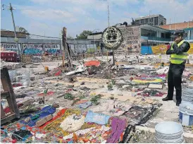  ?? [AP PHOTO] ?? A policeman stands Wednesday near a memorial where a building collapsed in last week’s 7.1 magnitude earthquake in Mexico City. Across Mexico City, hundreds of buildings were damaged beyond repair.