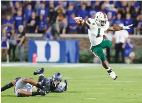  ??  ?? Miami’s Mark Walton jumps over Duke’s Ben Humphreys and Bryon Fields Jr. during the Hurricanes’ 31-6 win last Friday in Durham, N.C.