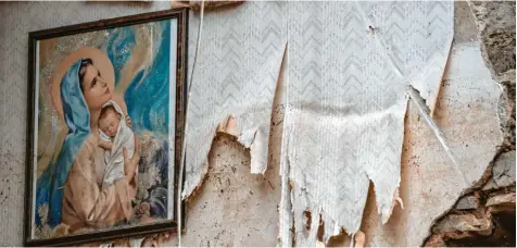  ?? Fotos (2): Boris Roessler, dpa ?? Ein Bild der heiligen Maria hängt im Dachgescho­ss eines zerstörten Hauses in Altenahr in Rheinland‰Pfalz.