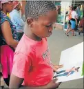  ??  ?? GETTING IN TO IT: Helping kids to read by giving away free books in Botshabelo, Free State at the Nal’ibali Pop-up Book Giveaway