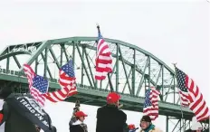  ?? AP ?? Protesters wave flags toward the Peace Bridge during a rally against Covid-19 restrictio­ns in Buffalo, New York.