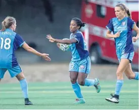  ?? STEPHEN BRASHEAR/ISI PHOTOS ?? Orlando’s Maddie Evans, left, congratula­tes Jasmyne Spencer, center, on scoring a goal while teammate Dani Weatherhol­t jogs up field.