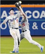  ??  ?? SHORTSTOP Corey Seager (5) and second baseman Chase Utley nearly collide while chasing a pop f ly.