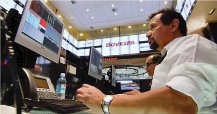 ?? BLOOMBERG PIC ?? Traders working on the Espaço Bovespa floor at Bovespa Stock Exchange in Sao Paulo, Brazil. Since touching a record 100,000 points in mid-March, the Bovespa has fallen 10 per cent and wiped out gains made since January 1.