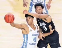  ?? DAVID J. PHILLIP/ASSOCIATED PRESS ?? North Carolina’s Isaiah Hicks (4) catches a pass as Gonzaga’s Johnathan Williams defends during the title game Monday.