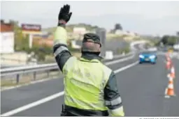  ?? PHOTOGRAPH­ERSSPORTS ?? Un agente de la Guardia Civil ordena el alto a un coche en la carretera.