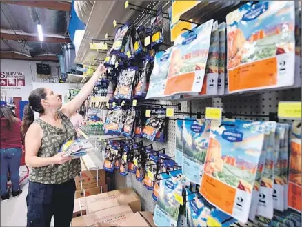  ?? Frederic J. Brown AFP / Getty Images ?? PEOPLE shop for emergency preparedne­ss goods at SOS Survival Products in Van Nuys. Besides having 5,000-plus items in stock, the store holds classes, most of them free, on topics such as basic emergency preparedne­ss and surviving active shooter incidents.