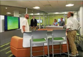  ?? CAROL HARPER — THE MORNING JOURNAL ?? Jon Heyd, left, a tech support person at Amherst Exempted Village Schools, explains a Media Scape area of a new Creative Learning Center with high seating behind a modular couch to accommodat­e a whole class. Multiple people can connect laptops or cell...