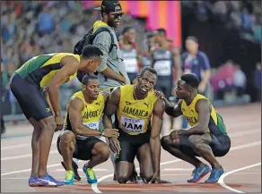  ?? Associated Press ?? Final Bolt: Jamaica's Usain Bolt is comforted by his teammates after suffering an injury in the 4x100 relay Saturday in the World Track & Field Championsh­ips in London.