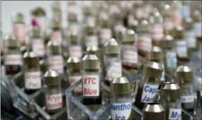  ?? REED SAXON—THE ASSOCIATED PRESS ?? This Dec. 4, 2013 file photo shows vials of flavored liquid at a store selling electronic cigarettes and related items in Los Angeles. On Wednesday U.S. health officials said teenage use of e-cigarette has reached “epidemic” levels in the U.S. and are calling on the industry to address the problem or risk having their flavored products pulled off the market.