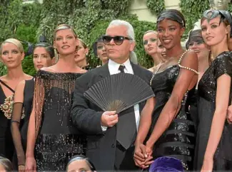  ?? —AP ?? Lagerfeld flanked by models including Linda Evangelist­a (left) and Naomi Campbell at the Chanel Fall-Winter 1996-97 haute couture collection.