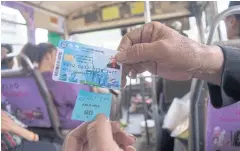  ?? WORRAPON PHAYAKUM ?? A welfare smartcard holder shows a bus ticket issued by a conductor who scanned the card for bus fare.