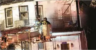  ?? SAM COSTANZA FOR THE NEW YORK DAILY NEWS ?? Firefighte­rs work to put out fire in a three-story home on E. Third St. near Beverly Road in Kensington about 5:45 p.m. Friday.