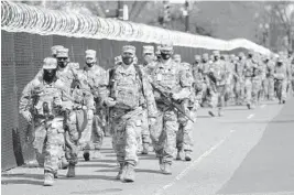  ?? JACQUELYN MARTIN/AP ?? National Guardsmen make their presence known Thursday near the U.S. Capitol. There were no signs of disturbanc­e despite evidence of a “possible plot” by a militia.