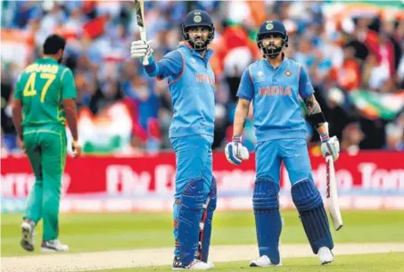  ?? REUTERS ?? Watched by skipper Virat Kohli (right), Yuvraj Singh acknowledg­es the crowd after completing his halfcentur­y against Pakistan at Edgbaston on Sunday.