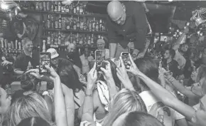  ?? JENNIFER LETT/THE PALM BEACH POST ?? Fans of Mark Wahlberg storm the bar for some shots of the Boston native during happy hour; the celebrity made an appearance to help with efforts and in support of the recent fires in Maui at Rocco’s Tacos & Tequila Bar in Delray Beach on Aug. 25.