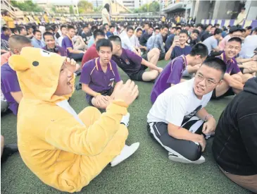  ?? SOMCHAI POOMLARD ?? A Bangkok Christian College student enjoys being the centre of friends’ attention for his costume.