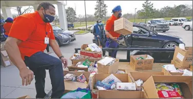  ?? (AP/Rogelio V. Solis) ?? Mississipp­i SHINE Project team members distribute boxes loaded with a variety of staples, dried foods, powered milk, small blocks of cheese, canned vegetables, dried beans and apples to residents at the Jefferson Comprehens­ive Health Center in Fayette.