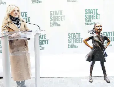  ?? MONICA SCHIPPER / GETTY IMAGES FOR STATE STREET GLOBAL ADVISORS ?? Rep. Carolyn Maloney (D-N.Y.) welcomes the popular four-foot statue known as Fearless Girl at an unveiling at her new home outside the NYSE on Monday.