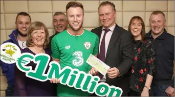  ??  ?? Wexford’s most recent Lotto millionair­e, Kevin O’Connor, receives his €1m cheque from Dermot Griffin, Chief Executive, National Lottery. Also pictured at National Lottery HQ are members of Kevin’s family (from left): Brian O’Connor, brother; Margaret...