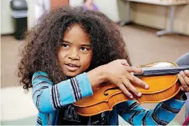  ?? [OKLAHOMAN ARCHIVES PHOTO] ?? Isabela Odhiambo tries out a violin during the Oklahoma City Orchestra League’s instrument playground in Oklahoma City in 2016. The instrument playground is part of the preshow activities for the Oklahoma City Philharmon­ic Discovery Family Series concerts.