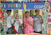  ?? G.N. JHA ?? People pose for picture after casting vote at Islam Nagar polling centre in Ghaziabad on Friday. —