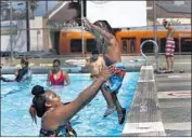  ?? Francine Orr Los Angeles Times ?? ASHLEY MOORE plays in the pool with her 2-yearold son, Alijah, in Highland Park on Wednesday.