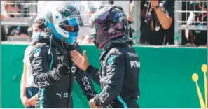  ?? (AFP) ?? Mercedes’ British driver Lewis Hamilton (right) congratula­tes Mercedes’ Finnish driver Valtteri Bottas after the qualifying round at the Austrian Formula One Grand Prix in Spielberg, Austria, on Saturday.