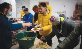  ?? ?? Aymen Jarnane, 23, from Morocco is served dinner Dec. 10 at a migrant refuge in Briancon.