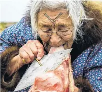  ?? KAITLYN VAN DE WOESTYNE ?? Bessie Omilgoetok of Cambridge Bay, Nunavut, cleans the blubber from a seal pelt with her ulu. Canada is renowned for its multicultu­ralism, yet a still unsettled issue in Canadian multicultu­ralism pertains to languages.