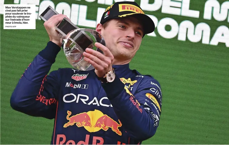  ?? PHOTO AFP ?? Max Verstappen ne s’est pas fait prier pour soulever le trophée du vainqueur sur l’estrade d’honneur à Imola, hier.