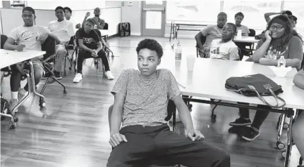  ?? ALGERINA PERNA/BALTIMORE SUN ?? At the the University of Maryland Baltimore Community Engagement Center, YouthWorks student Elijah Bell, 15, foreground center, attends a community organizing class with fellow YouthWorks students.