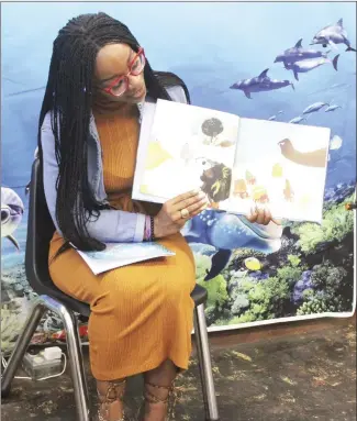  ?? Katie West • Times-Herald ?? Kinyuna Smith reads to children during the Forrest City Public Library’s Ocean of Possibilit­ies summer program. Smith read “Oona and the Shark” by Kelly DiPucchio before children attending the program participat­ed in a seahorse craft.