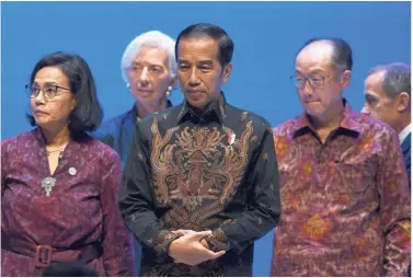  ?? — Reuters ?? Meeting of top guns: (From left) Indonesia Finance Minister Sri Mulyani Indrawati, Lagarde, Indonesia President Joko Widodo and Jim attending the Balifintec­h Seminar at the IMF-World Bank Annual Meeting in Nusa Dua, Bali.